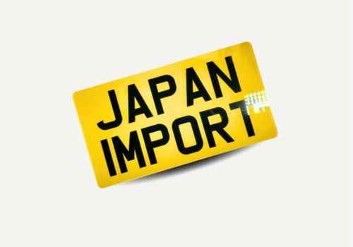 Japanese import number plate photo – 13x6.5 inch JDM size, white front and yellow rear, fitted to import car